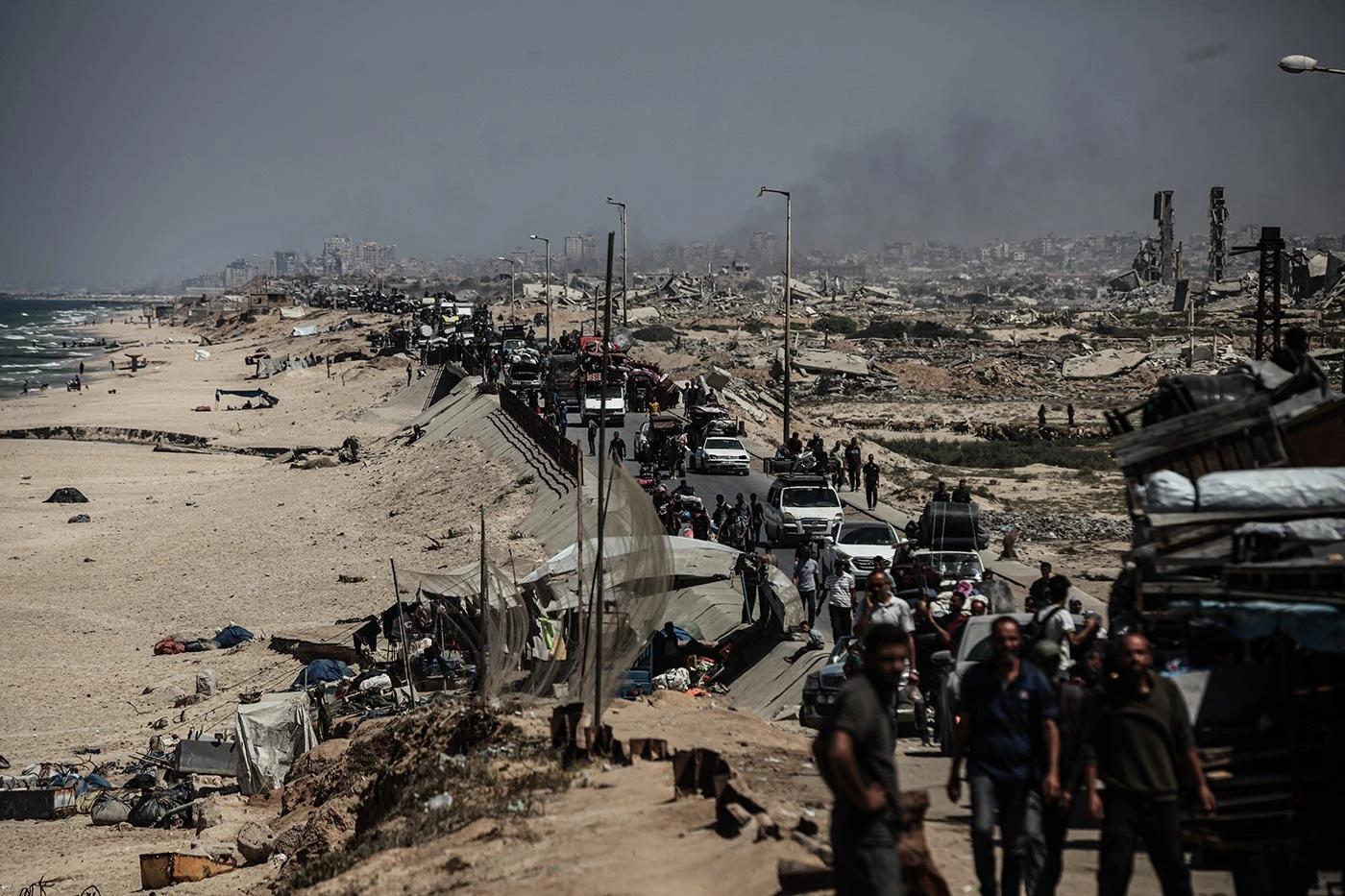 Dim se diže dok Palestinci napuštaju svoje domove sa svojim stvarima duž ulice Rashid zbog intenzivnih izraelskih vojnih napada